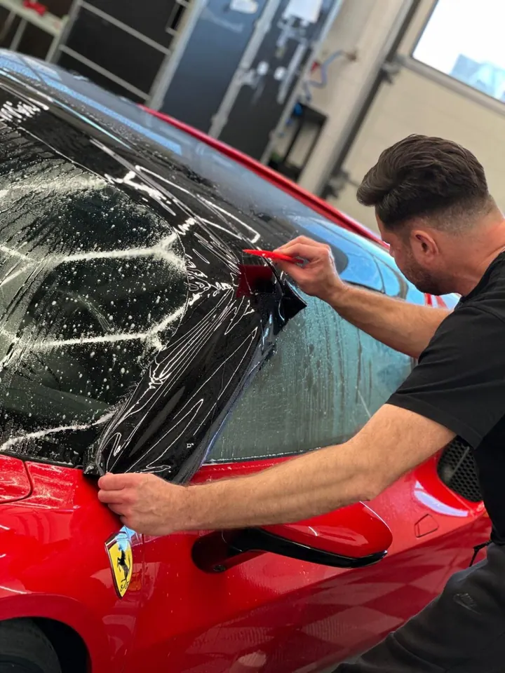 Aplikacja czarnej folii na słupku Ferrari